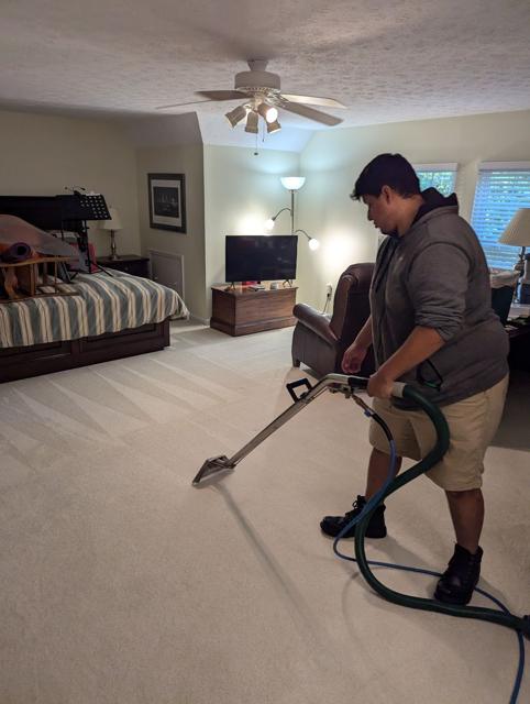 Steam cleaning wand finishing a bedroom carpet