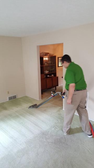 Excel technician cleaning wall-to-wall carpet in a customer's home