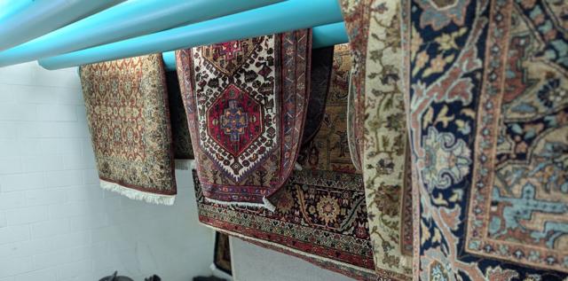 Oriental rugs on drying racks at the Akron facility