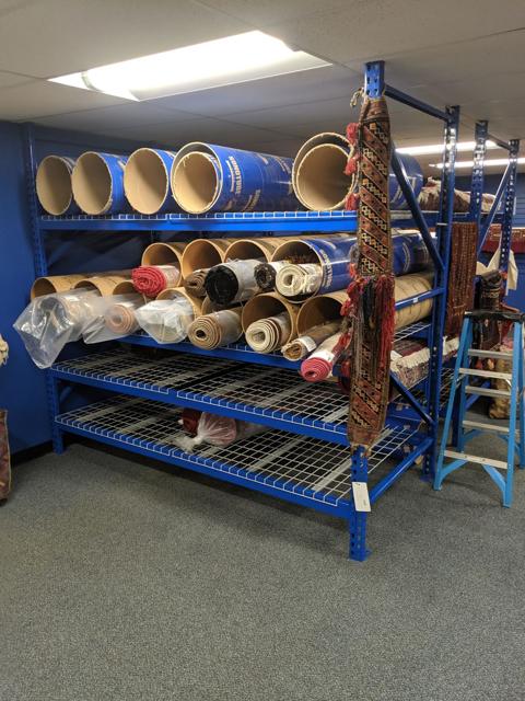 Rolled rugs stored on racks awaiting delivery